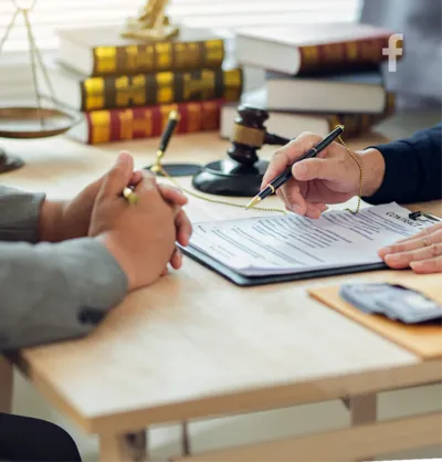 A gavel and law books beside a document being signed